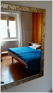 a mirror reflecting a bed in a room at STANZA ORO bagno con doccia idromassaggio in Udine