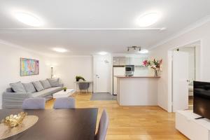 a living room with a couch and a table at Spacious & Cosy 2 Bedroom Apartment in Darling Harbour in Sydney