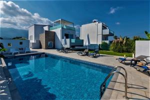 una villa con piscina di fronte a una casa di Xenos Villa 4 - Luxury Villa With Private Swimming Pool Near The Sea a Tigaki