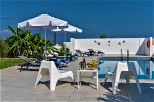 Xenos Villa 4 - Luxury Villa With Private Swimming Pool Near The Sea في تيجاكي: مجموعة كراسي ومظلة بجانب مسبح