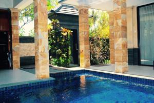 a swimming pool in a house with columns at Kori Maharani Villa - Two Bedroom Pool Villa 1 in Siyut