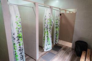 a shower with curtains with flowers on them in a bathroom at Clover Hostel in Mendoza