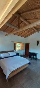 a bedroom with a large bed and a wooden ceiling at Casa Primitivo in Barichara