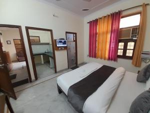a bedroom with a bed and a television in it at Hotel The Holiday Home in Rishīkesh