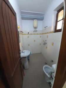a bathroom with a toilet and a sink at Hotel The Holiday Home in Rishīkesh