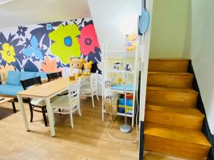 a dining room with a table and chairs and a staircase at Aroha Guesthouse Seoul Station in Seoul +46 photos