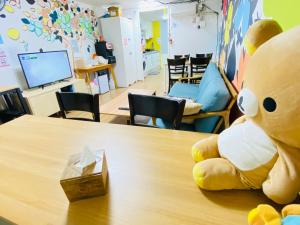 un grand ours en peluche assis au-dessus d'une table dans l'établissement Aroha Guesthouse Seoul Station, à Séoul