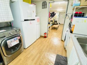 a kitchen with a washer and dryer in a room at Aroha Guesthouse Seoul Station in Seoul