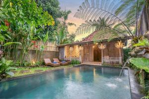 una piscina en un jardín con una casa en Pratiwi Ubud Villa en Ubud