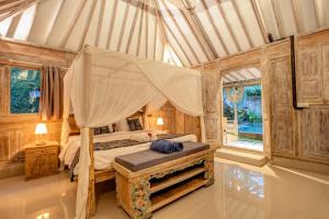 a bedroom with a canopy bed in a tent at Pratiwi Ubud Villa in Ubud