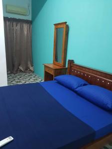 - une chambre bleue avec un lit et un miroir dans l'établissement 4 Bedroom House Indera Mahkota 8 Kuantan Homestay, à Kuantan