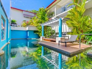 a swimming pool in front of a building at urban oasis in the heart of town in Port Douglas