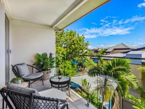 a balcony with chairs and a table with a view at urban oasis in the heart of town in Port Douglas