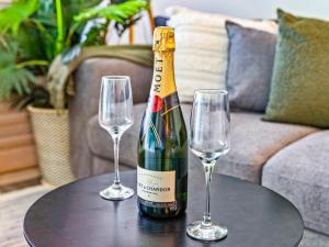 - une bouteille de champagne et 2 verres à vin sur une table dans l'établissement urban oasis in the heart of town, à Port Douglas