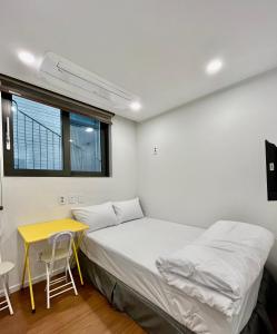 a bedroom with a bed and a table and a window at 318 Stay in Seoul