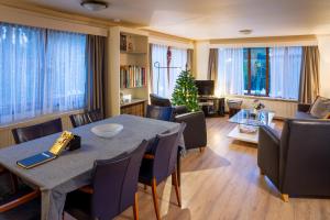 een woonkamer met een tafel en stoelen en een kerstboom bij Wonderful place on a quiet spot in the middle of the Netherlands in Putten