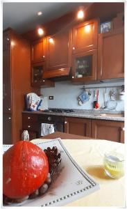 a kitchen with a plate with a large fruit on a table at STANZA ORO bagno con doccia idromassaggio in Udine