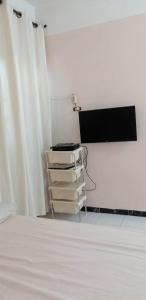 um quarto com um ecrã, uma mesa e um pódio em شقة الولاء Loyalty apartment em Dumyat al Jadidah
