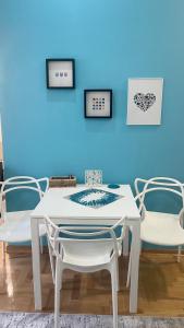 uma mesa branca e cadeiras num quarto com uma parede azul em Apartment Saraj-Bosna Free public Parking em Sarajevo