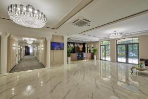un grand hall avec un lustre et un sol en marbre dans l'établissement Continental Hotel Samarkand, à Samarcande