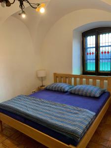 Schlafzimmer mit einem Bett mit blauer Decke in der Unterkunft VIP MiKU apartman 1 in Mikulov