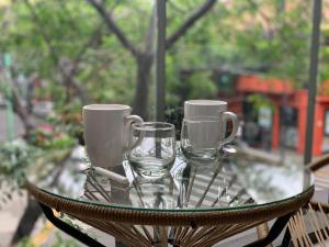 una mesa de cristal con dos vasos y tazas. en Excelente depto. en Almagro con Balcón a la calle en Buenos Aires