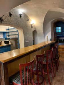 a bar with a row of chairs at a kitchen at VIP MiKU apartman 1 in Mikulov