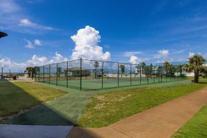 una pista de tenis con una red en un parque en Plantation 4514, en Gulf Shores