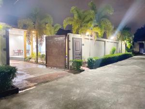 a house with a gate and palm trees at night at Sunny4 villa Pattaya in Ban Huai Yai
