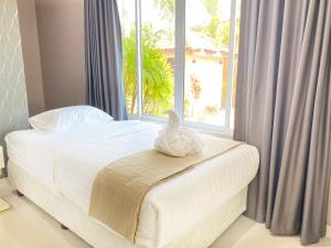 a white bird sitting on a bed with a window at Sunny4 villa Pattaya in Ban Huai Yai +22 photos