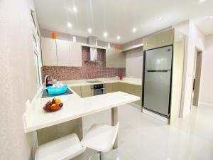 a white kitchen with a bowl of fruit on a counter at Sunny4 villa Pattaya in Ban Huai Yai