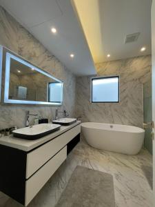 a bathroom with two sinks and a tub and a large mirror at MY HOTEL Al Lathba Pool Villa - Nizwa فيلا اللثبه-نزوى in Nizwa +10 photos