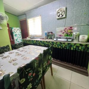 a kitchen with a table and chairs and a counter at Nur's Homestay in Seri Manjung