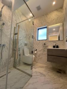 y baño con ducha, aseo y lavamanos. en MY HOTEL Al Lathba Pool Villa - Nizwa فيلا اللثبه-نزوى, en Nizwa