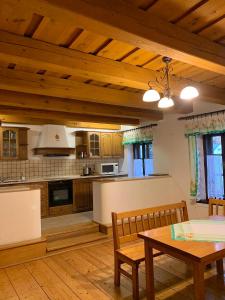 cocina con techos de madera, mesa y sillas en VIP MiKU apartman 2, en Mikulov