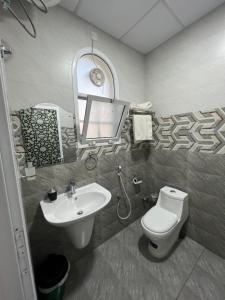 a bathroom with a sink and a toilet and a mirror at ضيافة الأمير The Prince Hospitality in Barka