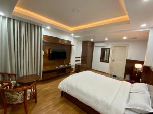 Dormitorio con cama, escritorio y TV en YULOKO GUEST HOUSE en Katmandú