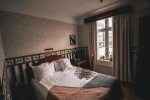 una camera da letto con un letto con lenzuola bianche e una finestra di Mojo Hotell a Örebro