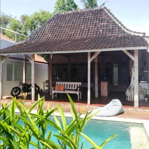 a house with a pool and a gazebo at The Joglo Kedungu, Traditional Teakwood in Tanah Lot
