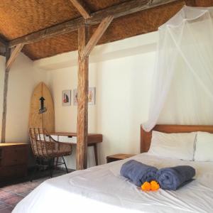 ein Schlafzimmer mit einem Bett mit blauen Handtüchern darauf in der Unterkunft The Joglo Kedungu, Traditional Teakwood in Tanah Lot