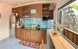 - une cuisine avec des placards en bois et un réfrigérateur dans l'établissement Te House, à Hô-Chi-Minh-Ville