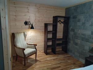 ein Zimmer mit einem Stuhl und einem Bücherregal in der Unterkunft Algara hut in Panichishte