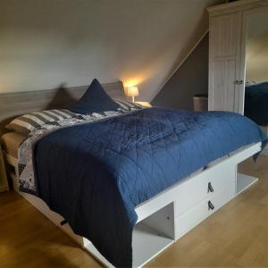 1 cama con edredón azul en un dormitorio en Ferienhaus Helmsand 2, en Friedrichskoog
