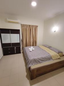 a bedroom with a bed with two towels on it at Balini Home Tiara Desaru in Desaru