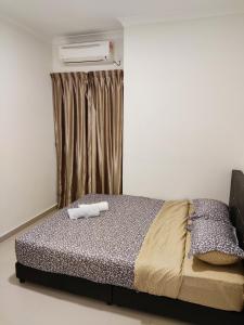 um quarto com uma cama com duas toalhas em Balini Home Tiara Desaru em Desaru