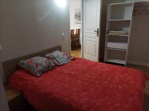 - une chambre avec un lit et une couette rouge dans l'établissement Appartement Eaux bonnes, à Eaux-Bonnes