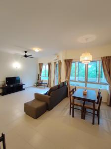 een woonkamer met een bank en een tafel bij Balini Home Tiara Desaru in Desaru