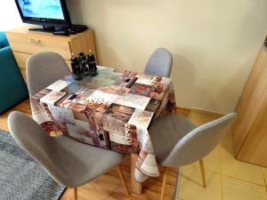 a dining room table with chairs and a quilt on it at Студио D-41 в Апарт-хотел Боровец Гардънс in Borovets