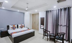 ein Schlafzimmer mit einem Bett, einem Tisch und einem Stuhl in der Unterkunft FabExpress Dream Living in Neu-Delhi