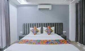ein Schlafzimmer mit einem großen Bett mit bunten Kissen in der Unterkunft FabExpress Dream Living in Neu-Delhi